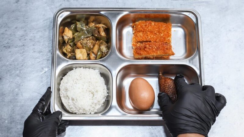 Pekerja menunjukan menu paket makanan bergizi gratis (MBG) di dapur Satuan Pelayanan Pemenuhan Gizi (SPPG) Lamongan, Jawa Timur. (Antara/Rizal Hanafi)
