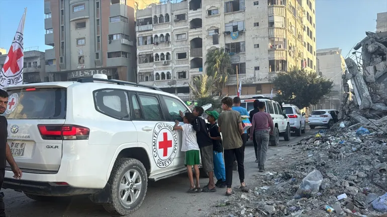 Warga Palestina menyambut kendaraan ICRC saat mereka berkendara melalui Gaza utara. (Hamza Z H Qraiqea/Anadolu)