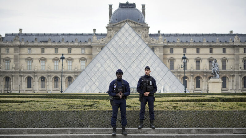 Dua anggota polisi sedang berjaga di luar Museum Louvre (Remon Haazen/Getty Images)